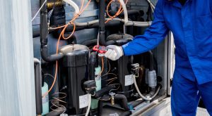 The technician checking power lines of the heat exchanger with current clamps.